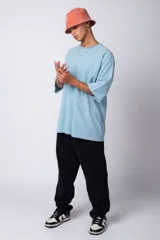 Remera verde militar de corte oversize, confeccionada en algodón 100% con cuello redondo y manga corta. Presenta un pequeño logo estampado en la parte superior de la espalda.