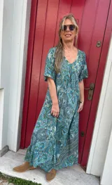 Vestido largo de seda con estampado floral en tonos verde y celeste, escote en V y mangas cortas.