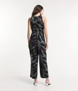 Mono largo sin mangas de viscosa twill color negro con estampado de follaje en blanco. Tiene cuello redondo, cierre con botón en la espalda y bolsillos laterales.