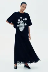Remera negra de algodón con cuello redondo y mangas cortas. Estampado frontal con un jarrón con flores en blanco y negro.