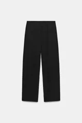 Pantalón negro de tiro alto con bolsillos delanteros y cierre frontal con cremallera y gancho metálico.