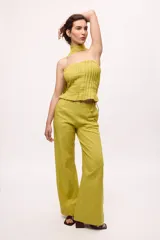 Pantalón recto color amarillo con rayas verticales blancas.