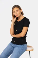 Remera negra de tejido rib con cuello redondo y botones fijos. De manga corta, confeccionada en algodón y elastano.