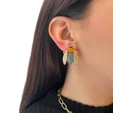 Par de aros pequeños con forma de insecto, hechos en base metálica dorada con resinas de colores, detalles de strass en las alas y ajuste con perforación.