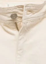 Pantalón de jean culotte color crema, tiro alto, con cierre de cremallera y botón, trabillas, bolsillos traseros, bajo deshilachado y tejido elástico.