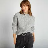 Sweater gris de punto grueso con cuello alto y mangas largas.