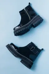 Botas de cuero negras con plataforma y hebilla lateral.