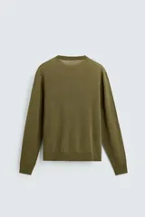 Jersey negro de lana con acabado mercerizado, corte relaxed fit, cuello redondo y mangas largas con terminaciones en rib.