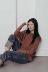 Sweater color crema de tejido de punto trenzado, con cuello redondo y corte holgado.