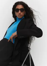 Jersey negro de punto fino con cuello alto, manga larga y terminaciones de canalé.