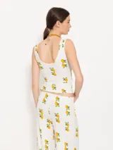 Musculosa blanca con estampado de limones, confeccionada en tejido de punto acanalado. Presenta escote en V tanto en delantero como en espalda, bien cavados para un look femenino y estilizado.