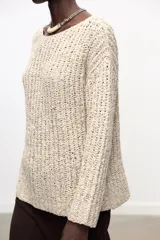 Sweater color crema de tejido de punto grueso, con cuello redondo amplio y mangas largas.