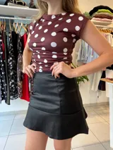 Top negro con lunares blancos, cuello alto y corte ajustado.