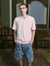 Polo de manga corta color crema, con cuello tipo polo y corte relajado.
