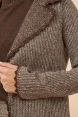 Chaqueta color crudo de lana fina sin teñir, de corte recto con cuello solapa y mangas 3/4.