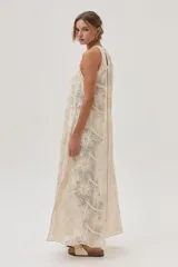 Vestido largo de red color crudo con estampado de flores, corte recto y cuello halter.