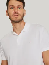 Chomba blanca de algodón con cuello clásico, tapeta de dos botones, corte regular y logo de Tommy Hilfiger bordado en el pecho.