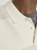 Polo de manga larga a rayas horizontales color crema y gris, con cuello clásico y cierre de medio botón.