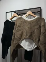 Sweater tejido de punto color crema, con cuello redondo y mangas largas.