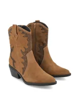 Botín de estilo western confeccionado en gamuza color marrón, con diseño de costuras decorativas y tachas en forma de llama. Cuenta con taco bloque y caña media.