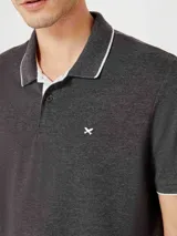 Camisa polo color rosa claro con cuello clásico, tapeta de dos botones y bordado de logo en el pecho. Presenta ribete azul marino en cuello y mangas. Corte clásico.