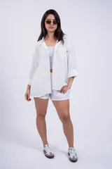 Camisa negra de corte amplio, con cuello clásico, cierre frontal con botones, manga larga con puños arremangados y bolsillo de parche en el pecho.