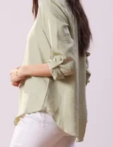 Blusa color beige de poliéster con escote en V y mangas 3/4 regulables con presilla y botón.