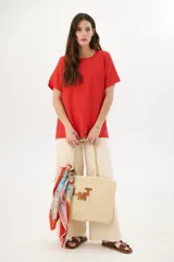 Blusa manga corta color rojo con cortes laterales y abertura abotonada en la espalda. Los pespuntes a contratono resaltan el escote y los cortes.