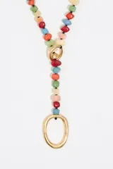 Collar largo con cuentas de piedra multicolor y arandela de metal dorado.
