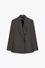 Blazer gris con diseño de líneas verticales, cuello solapa, manga larga con hombreras, bolsillos delanteros de vivo y cierre frontal cruzado con botones.