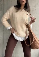 Buzo color beige de hilo con mangas largas y detalle de calado en los hombros.