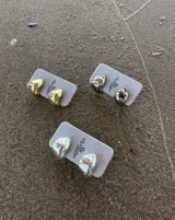 Aros pequeños de bronce con forma irregular y acabado liso, estilo huggie o argolla gruesa.