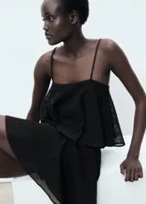 Vestido corto negro con tirantes finos, escote recto y falda con volados.