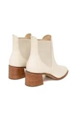 Botines Chelsea de cuero color crema, con elásticos laterales en tono beige y tacón bloque de madera.