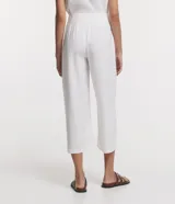 Pantalón blanco acampanado de viscosa con cintura mediana, cierre con botones y bolsillos laterales.