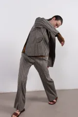 Blazer gris con rayas verticales marrones, solapas de muesca, cierre con un botón y bolsillos con solapa.