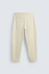 Pantalón chino color beige, corte recto, con bolsillos laterales y traseros. Cierre frontal con cremallera y botón.