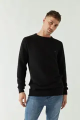 Sweater mostaza de punto con cuello redondo, mangas largas y logo bordado en el pecho. Corte slim fit.
