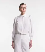 Camisa blanca de crepé con cuello solapa, abotonada, mangas largas abullonadas y sin estampado.