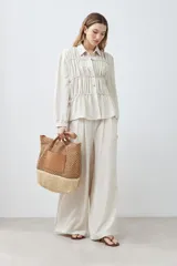 Camisa beige melange con frunces en el frente, de manga larga y cuello camisero.