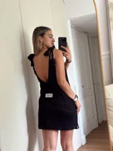 Vestido mini tejido en algodón y lurex, color negro. Espalda con escote en V y tiras con borlas que regulan el largo.
