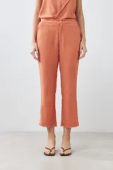Pantalón celeste de lino, corte recto, con efecto desflecado en el ruedo.