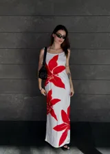 Vestido largo blanco con estampado de flores rojas, de breteles finos y corte recto.