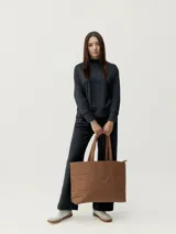 Bolso shopper negro acolchado con 2 asas. Tejido resistente. Cierre principal con cremallera, patrón acolchado exterior con diseño de costuras. Bolsillos interiores para mayor comodidad.