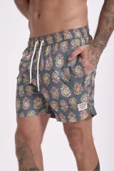 Short de baño con estampado de flores de loto y hojas en tonos amarillo, naranja y verde sobre fondo azul.