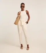 Pantalón carrot de sarga color crudo, con cintura elástica, lazo ajustable y bolsillos laterales.