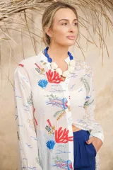 Camisa larga blanca con estampado de motivos marinos en tonos rojo, azul y verde.