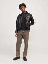 Chaqueta de cuero negra con cuello clásico, cierre frontal con cremallera, mangas largas con puños abotonados y bolsillos laterales con cremallera.