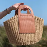 Bolso de mimbre trenzado con detalles en cuero ecológico marrón, sin cierre.