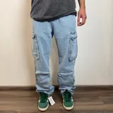 Pantalón jean color beige, de corte holgado y estilo cargo, con múltiples bolsillos laterales.